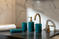 Four-piece hand-cast resin bath set in deep teal on dark honed stone vanity, luxury hotel bathroom