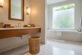 Large pandan waste bin beside hotel bathroom vanity with teak accessories on marble counter and warm wall sconce
